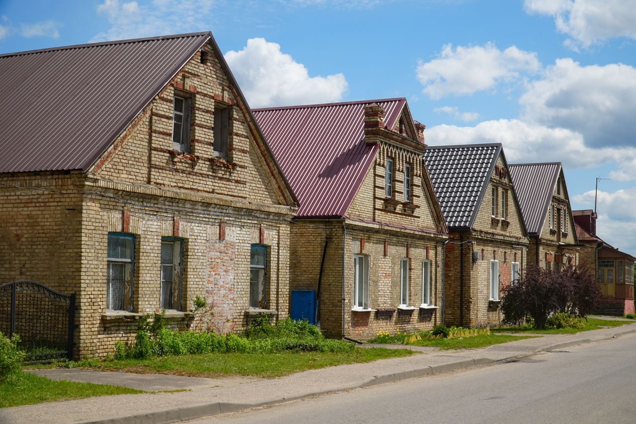 Charming brick houses with gable roofs on a sunny day in Grodno Region, Belarus.